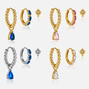 Primo piano di set di orecchini in acciaio placcato oro 18k con gemme colorate a goccia
