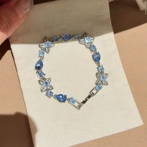 Detailed close-up of an elegant blue crystal flower bracelet placed on a beige jewelry pouch