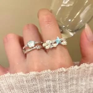 Detail of summer style starfish and shell adjustable ring with pearls and blue accents