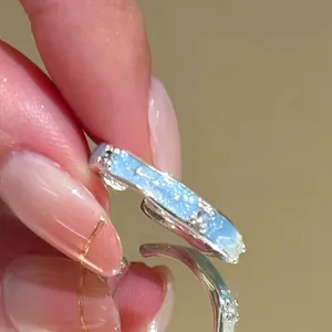 Close-up detail of silver adjustable ring with blue sea star glitter motif and texture