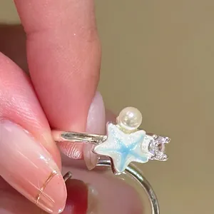 Detailed close-up of adjustable silver ring featuring a blue starfish and pearl accent