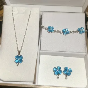 Detail van blauwe kattenoog klaver sieradenset met ketting, armband en oorbellen