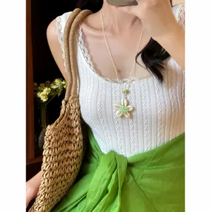 Nahaufnahme einer süßen Perlenkette mit grüner Muschelblüte für den Sommerlook am Strand