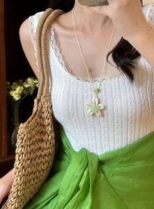 Detailansicht einer süßen grünen Blumen-Perlenkette, getragen von einem Modell für den Sommer.