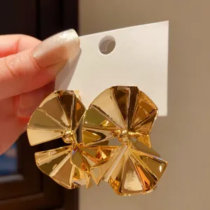 Close-up detail of vintage golden fan-shaped earrings with a polished metallic finish