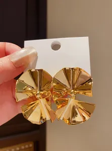 Detailed view of large gold polished irregular fan-shaped vintage statement earrings