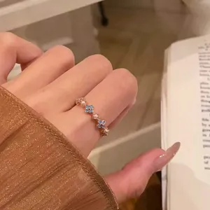 Detailed close-up of a vintage-style ring featuring small blue flowers and pearls.
