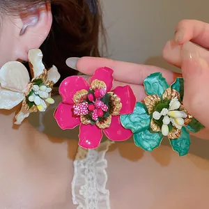 Detailed macro view of vintage enamel flower earrings in pink, white, and turquoise colors