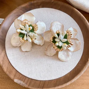 Close-up view of vintage enamel flower stud earrings featuring intricate stamen details
