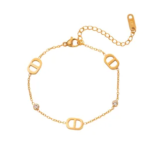 Vue détaillée d'un bracelet en acier titane doré avec breloques D et cristaux
