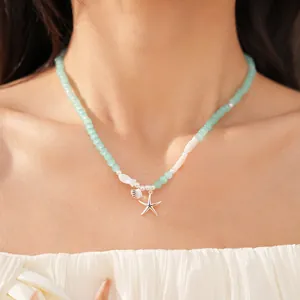 Detailopname van een mintgroene kralenketting met zeester op de nek van een vrouw voor vakantie.