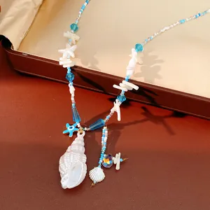 Gedetailleerde weergave van handgemaakte schelpen- en zeesterrenketting met blauwe kralen.