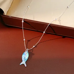Detailopname van een iriserende vishanger aan een zilveren ketting met heldere steen.