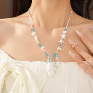 Close-up van strandachtige kralenketting met blauwe glazen kralen en een schelphanger