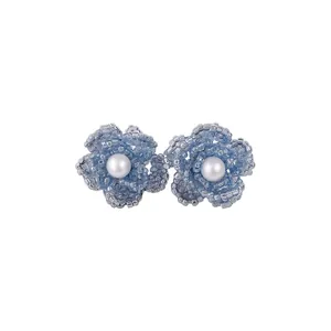 Exquisitos pendientes de flor de cristal azul tejidos con elegante perla central