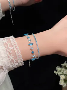 Detailed view of elegant light blue zircon marquise and tennis bracelets on a wrist