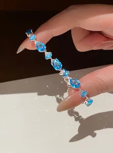 Detailed view of adjustable silver bracelet with sparkling blue zircons in sunlight