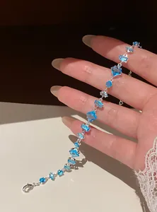 Detailed view of an elegant silver-tone bracelet featuring multi-shaped blue zircon stones