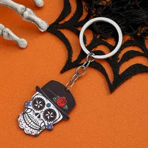 Close-up of gothic sugar skull keychain with black hat and red rose detail