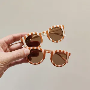 Stylish striped children's sunglasses in earth tones and pink for summer sun protection