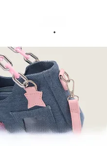 Detail of blue denim shoulder bag featuring pink star patch and stylish chain strap