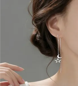 Elegant silver star and moon tassel ear thread earrings shown on an Asian model