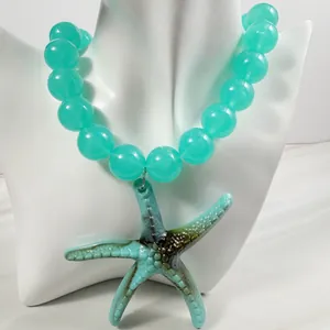 Detailansicht einer türkisfarbenen Perlenkette im Strandstil mit Seestern-Anhänger.