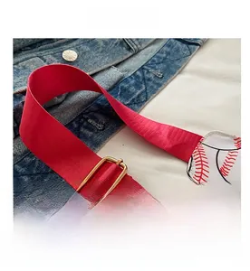Close-up of the adjustable red nylon strap on a baseball-themed crossbody chest bag