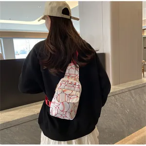 Detail view of a compact nylon chest bag featuring a stylish baseball print on a model