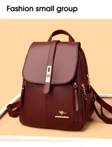 Detailed view of a stylish burgundy faux leather backpack with a golden kangaroo logo.