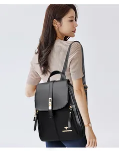 Close-up of a stylish black leather backpack for women featuring gold-tone metal hardware