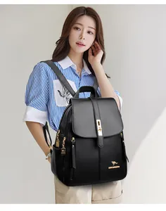 Detail view of a model wearing a chic black leather backpack with gold accents for women