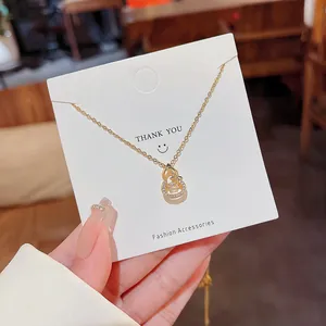 Golden titanium steel hulu necklace with a dancing stone pendant on a thank you card