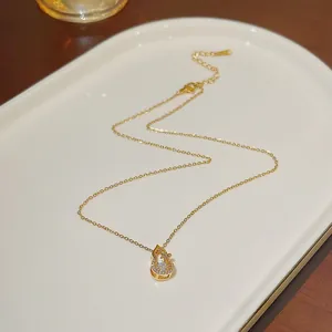 Detail of gold gourd pendant with white zircon inlays and lobster clasp chain