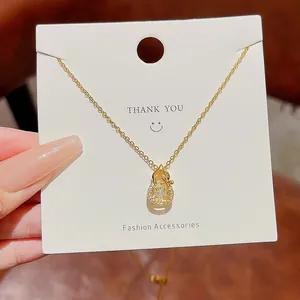 Macro shot of gold stainless steel gourd pendant with a dancing zircon stone and tiny diamonds