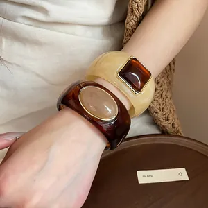 Close-up of stylish retro acrylic bangles featuring tortoiseshell and beige resin inlays