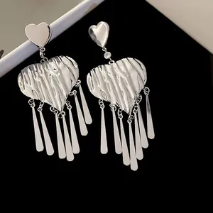 Zilveren hart oorbellen met gehamerde metalen textuur en lange platte kwastjes