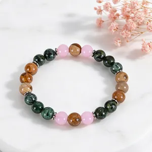 Detail view of African Turquoise and pink jade beaded bracelet on marble background