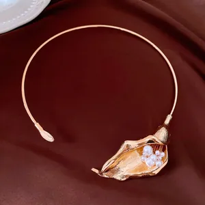 Dettaglio squisito di un'elegante collana choker a forma di calla dorata con perle