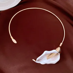 Primo piano di un elegante ciondolo a forma di calla d'oro su una collana girocollo in metallo