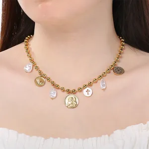 Gros plan du collier rétro en acier titane avec médailles de Marie et perles baroques