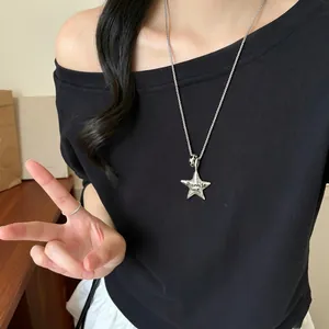 Chic silver star pendant necklace with Promise me engraving worn by a model in black