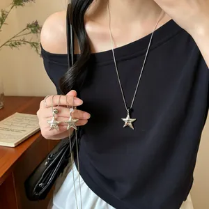 Detailed lifestyle shot of a stylish silver star pendant necklace on a long chain