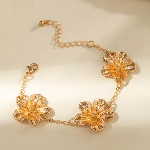 Close-up detail of an elegant gold-toned flower anklet with intricate textured petals