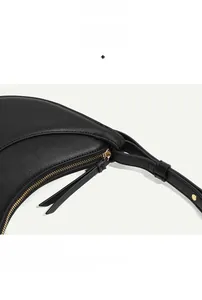 Detail of high-quality black pebble leather lunar bag with gold zipper and hardware