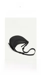 Close-up of black crescent leather bag with lychee texture and gold-tone hardware