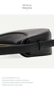 Detail view of black lychee grain leather saddle bag with gold metal zipper and strap