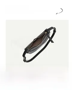 Detail view of black pebbled leather crescent bag with gold hardware and zipper
