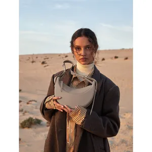 Minimalist leather crescent saddle bag in taupe with adjustable strap for women