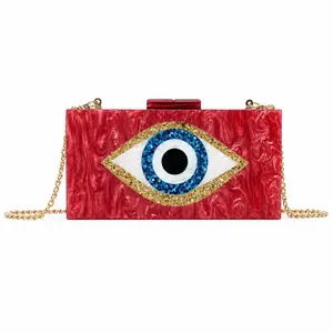 Macro view of the red marbled acrylic clutch bag featuring a striking evil eye design.